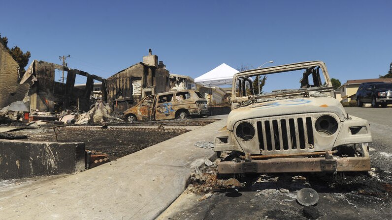 The remains of burned vehicles and homes