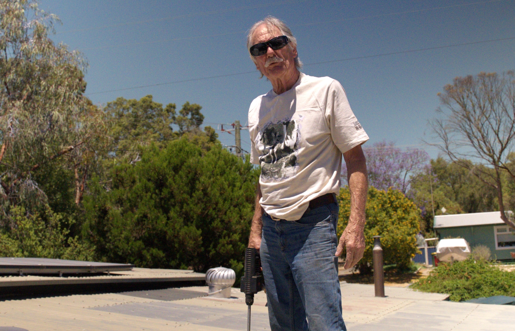 Uma foto do residente de Greenbushes, Rick Fryer, sentado em sua casa.