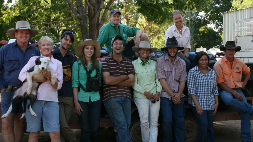 Owners with nine backpackers at Sutherland Station posing for a photo under the shade of a tree
