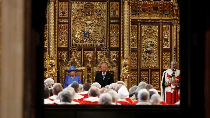 The Queen and Prince Charles sit side by side in front of the House of Lords.