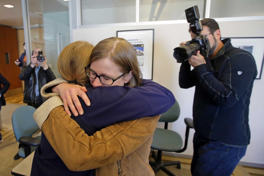 Pulitzer winners from the Salt Lake Tribune hug in their office following the announcement