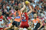 Isaac Heeney catches the ball in front of Lachie Whitfield