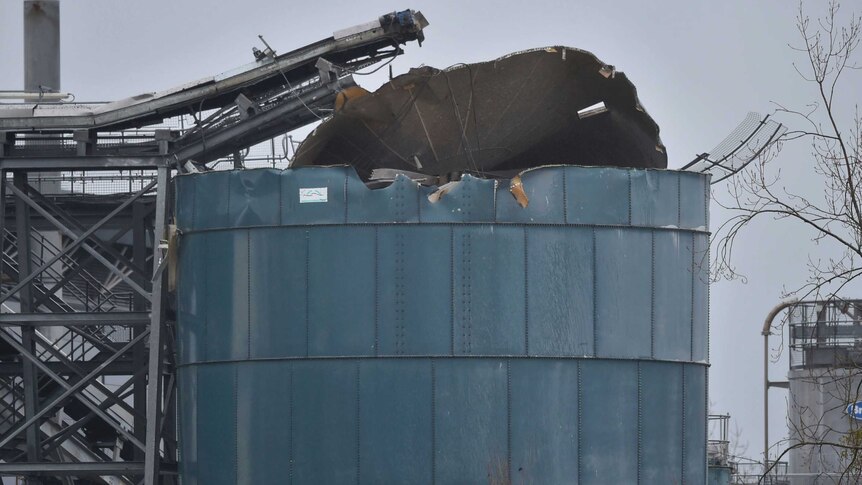 Large metal silo with roof torn off