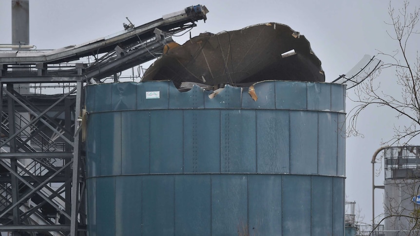 Large metal silo with roof torn off