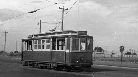 An old black and white photo of a 1950's tram