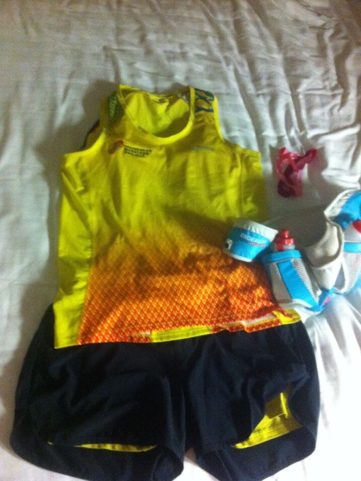 A yellow sports top with black shorts and sports gear.