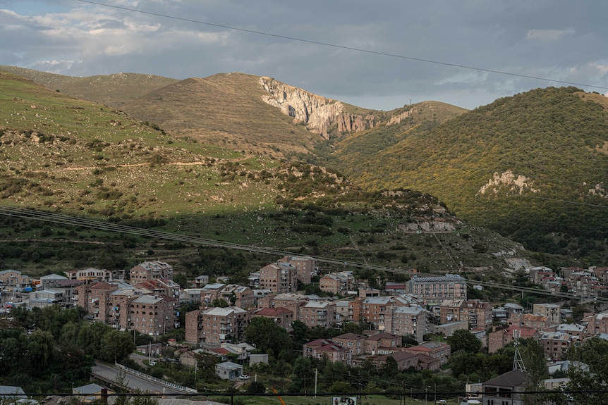 A sprawling city nestled in a mountainous landscape.