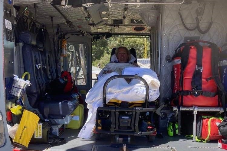 A woman laying on a stretcher bed inside a medical chopper