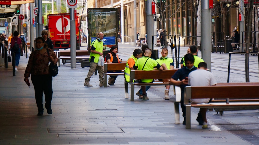 Tradesmen and pedestrians on a shopping strip