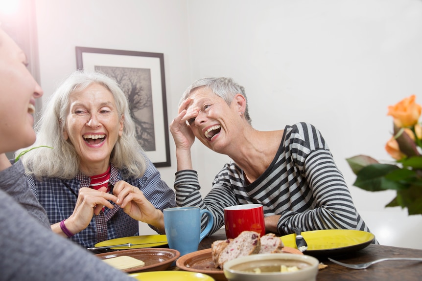 Friends drinking coffee together laughing