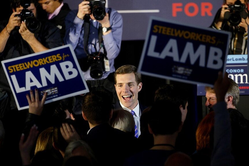 Conor Lamb smiles in front of supporters and photographers.