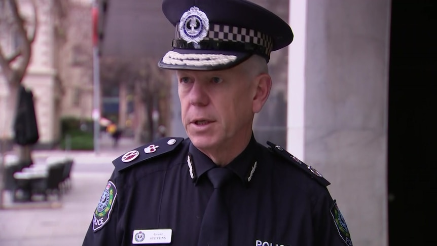 Man wearing police uniform talking and looking off camera