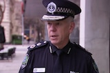 Man wearing police uniform talking and looking off camera