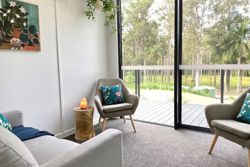 Room with soft-coloured furnishings, lamp, floor to ceiling glass window