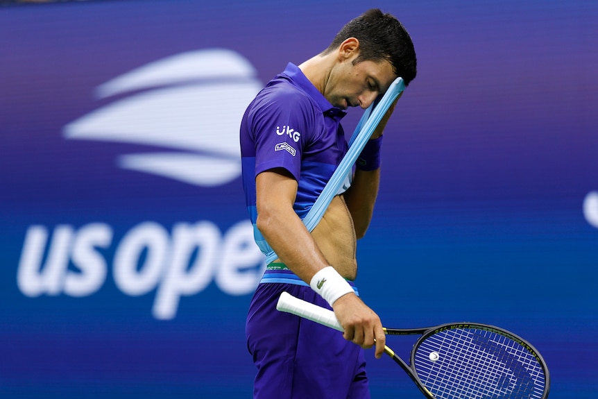 Novak Djokovic wipes his forehead with his t-shirt