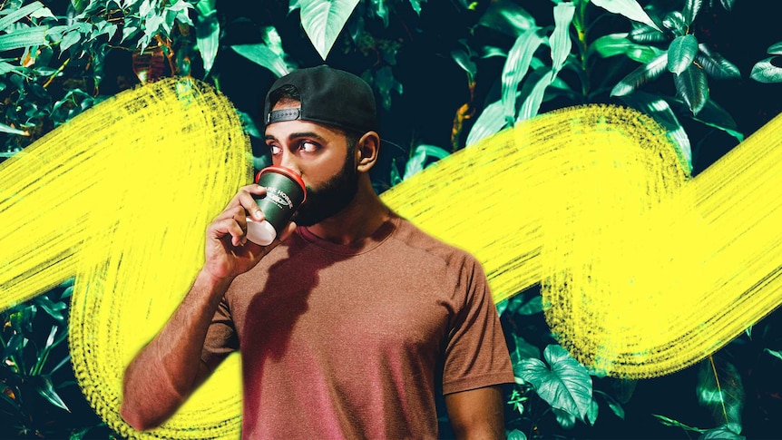 A man stands in front of some bushes wearing a t-shirt and cap, drinking a cup of takeaway coffee as he thinks about his health.