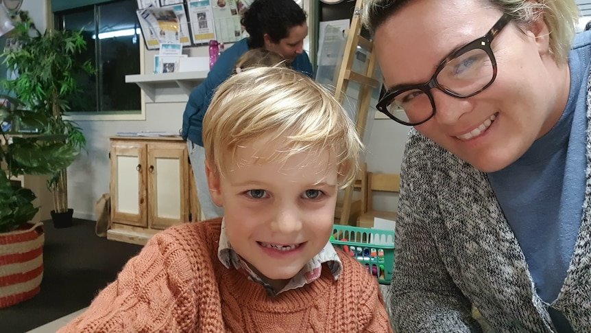 Woman sits with son smiling