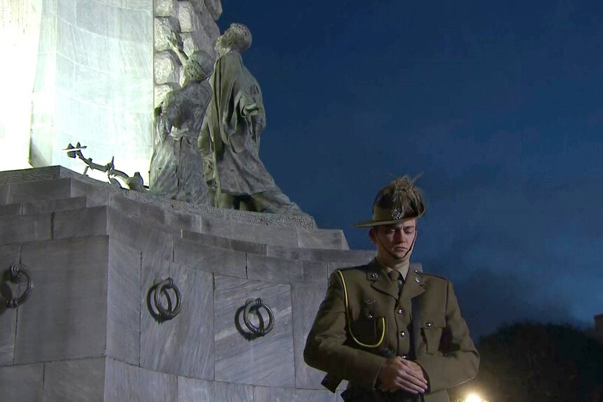 A soldier in uniform next to Adelaide's National War Memorial on Anzac Day.