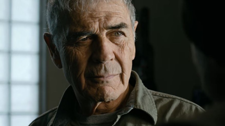 A close-up of an old man played by actor Robert Forster