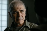 A close-up of an old man played by actor Robert Forster