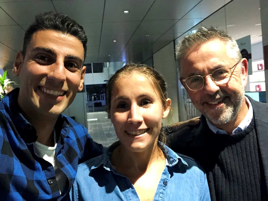 Two men and a woman looking at camera.