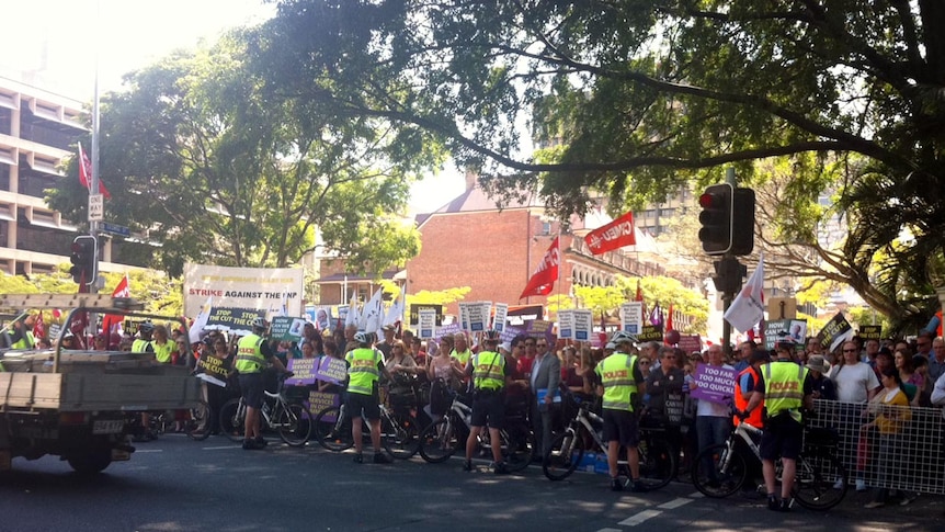 Protesters and police line Alice Street in Brisbane CBD