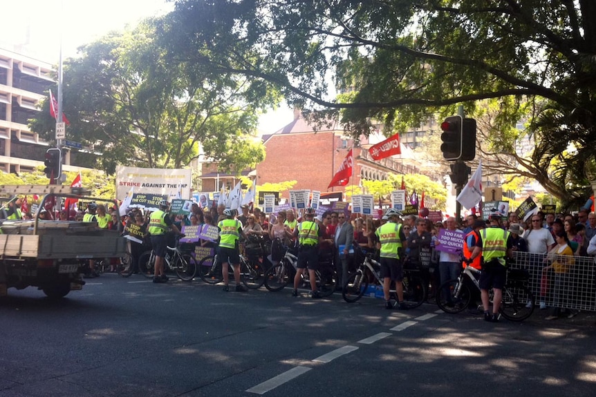 Protesters and police line Alice Street in Brisbane CBD