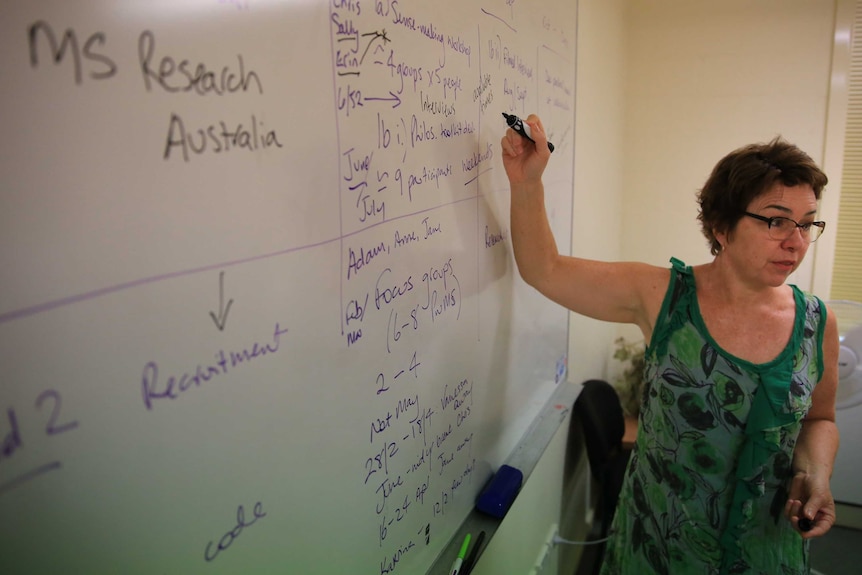 Dr Jane Desborough points at a whiteboard while teaching a class.