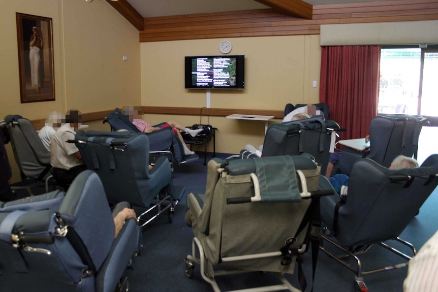 Nursing Home residents in chairs around a television.