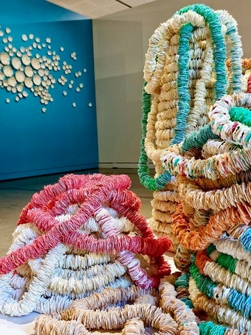 Piles of plastic bread tags twisted into a sculpture in a museum