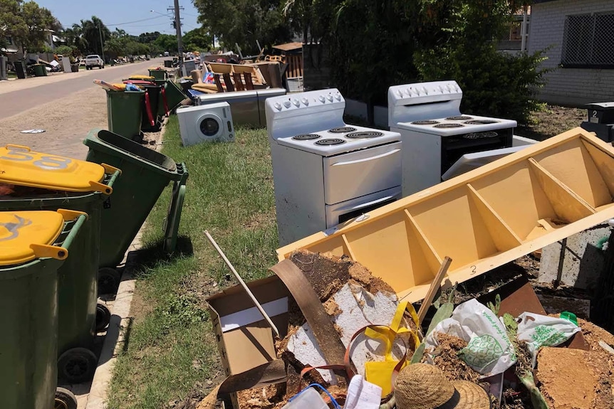 Piles of flood-damaged household goods line a street front in the Townsville suburb of Mundingburra Mon Feb 11 2019.