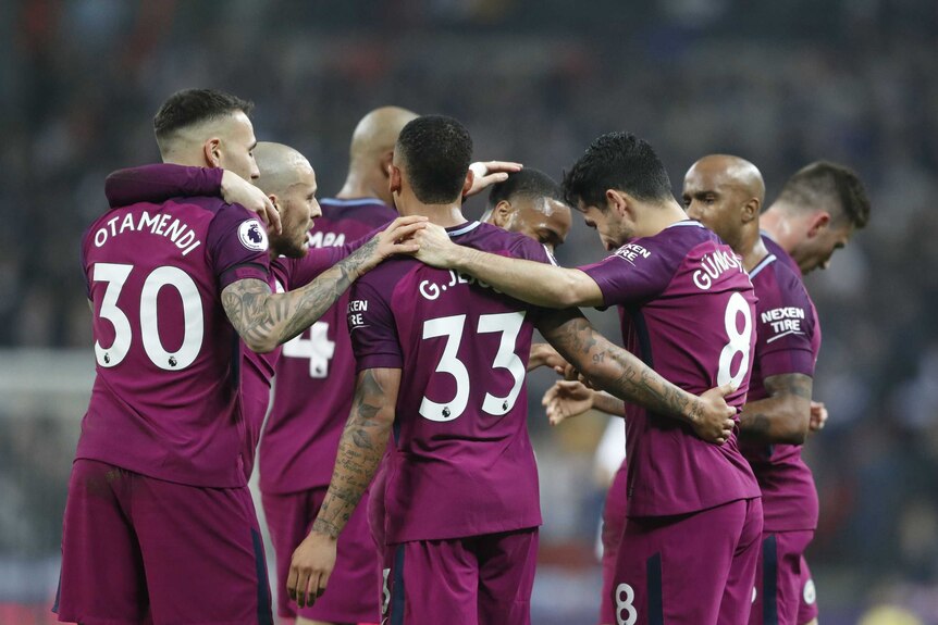 Manchester City players celebrate scoring goal at Wembley
