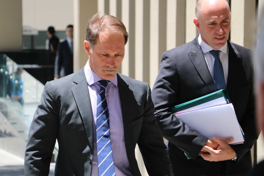 Paul Dion Thompson (left) looks down as he walks away from the Perth Magistrate's Court on January 20, 2016.