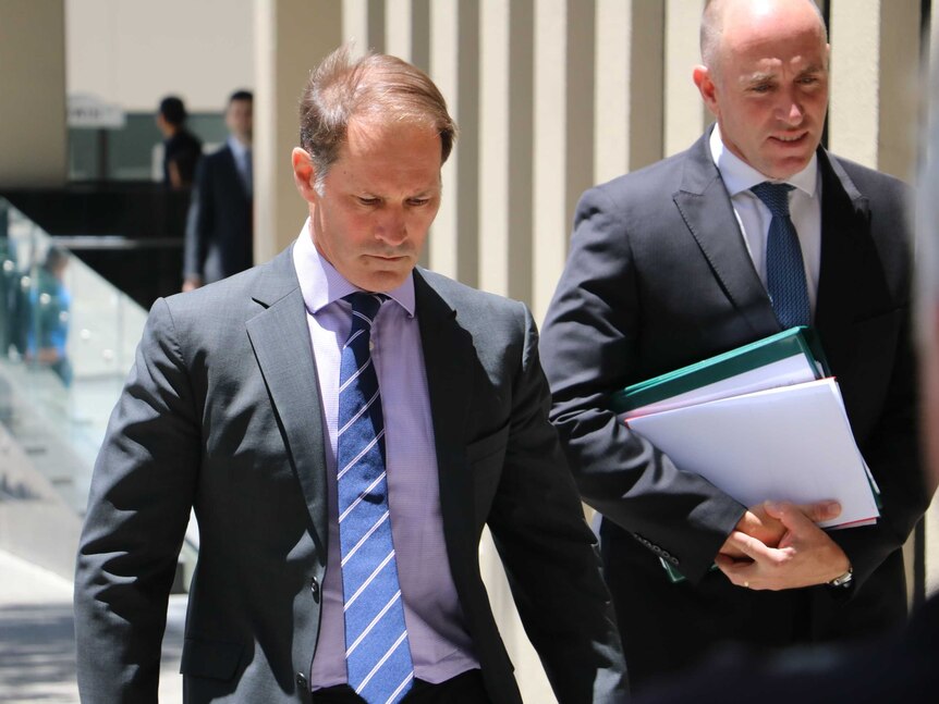 Paul Dion Thompson (left) looks down as he walks away from the Perth Magistrate's Court on January 20, 2016.