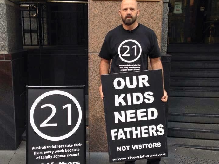 man in black shirt holding sign in front of a court house