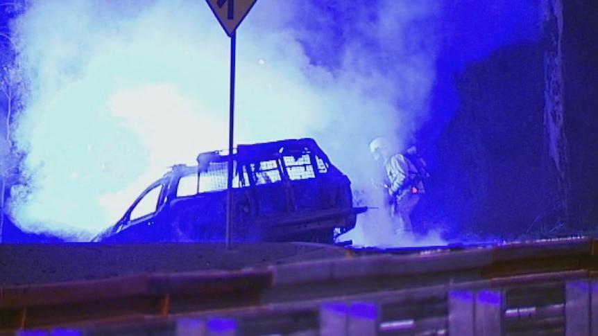 Firefighters work to douse a car ablaze after a high-speed chase near Brisbane