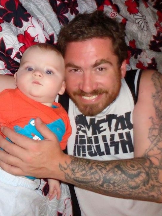 Man with tattooed sleeve and small baby
