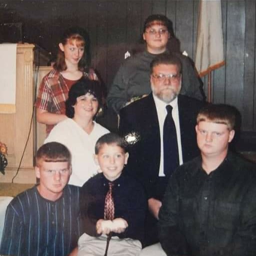 A photo of a family sitting on steps in their home