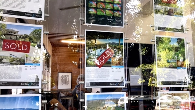 The window of a Bellingen real estate agent showing sold signs.