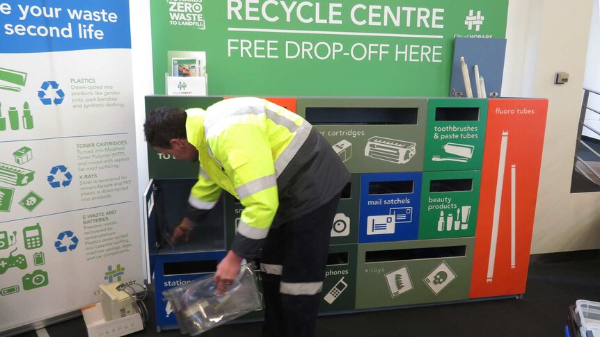 A council worker empties the Waste Wall recycle drop off facility, 16 Elizabeth Street, Hobart.