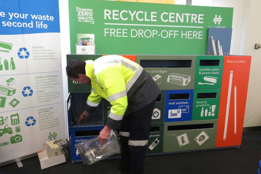A council worker empties the Waste Wall recycle drop off facility, 16 Elizabeth Street, Hobart.