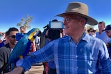 Prime Minister Malcolm Turnbull holds a macaw on his arm.