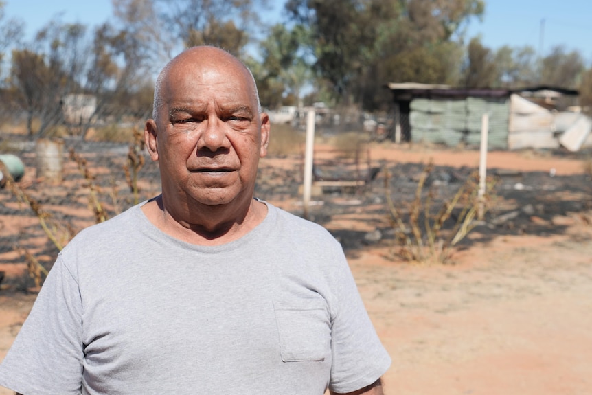 Man stands in front of fire damage