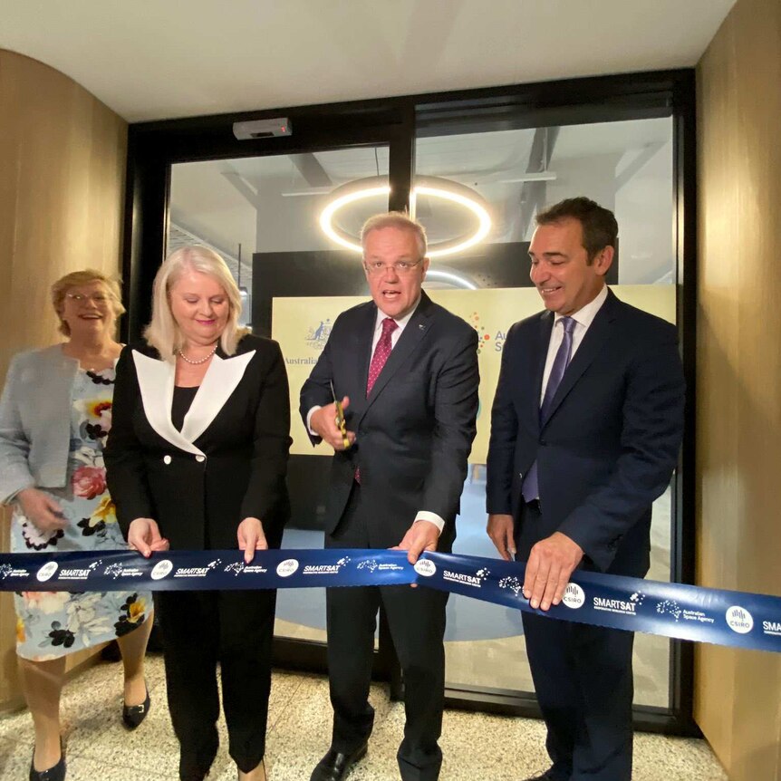 Prime Minister Scott Morrison holding a blue ribbon and scissors, standing alongside Premier Steven Marshall