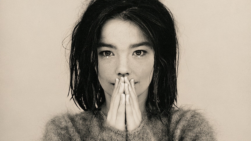 black and white photo of bjork with her hands clasped together and raised to her face
