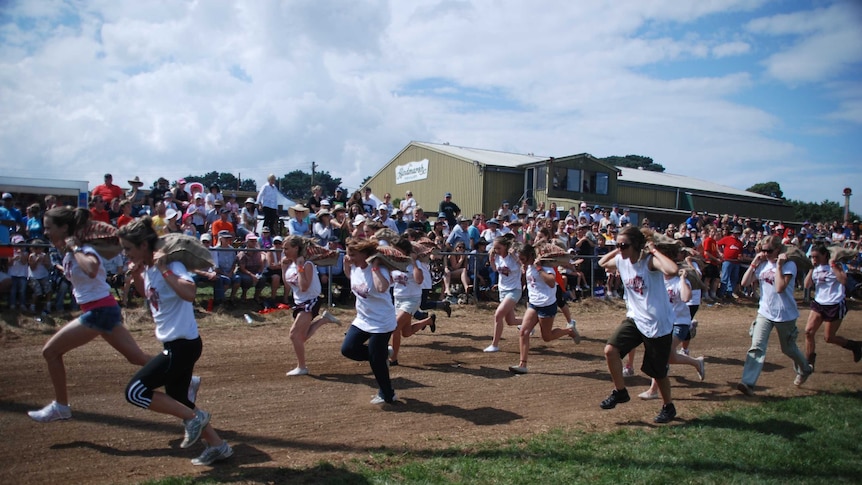 Women race carrying potato sacks at the Robertson Show.