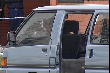 A car with bullet holes through the window.