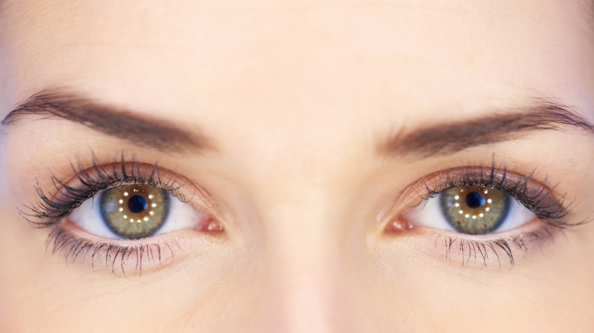 A close up photo of women's green eyes