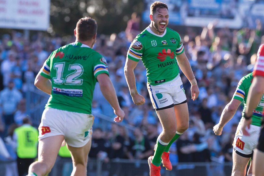 Aidan Sezer is in mid-air, smiling as his teammates begin to converge around him.
