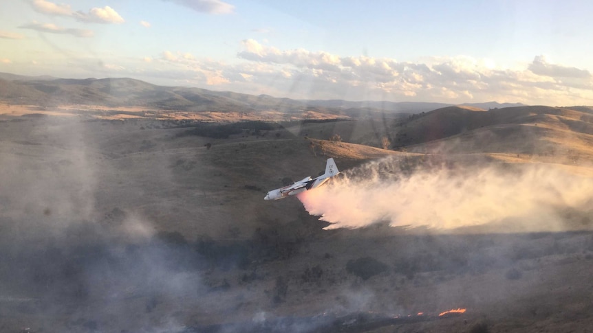 An aircraft drops retardant on the Carwoola fire.